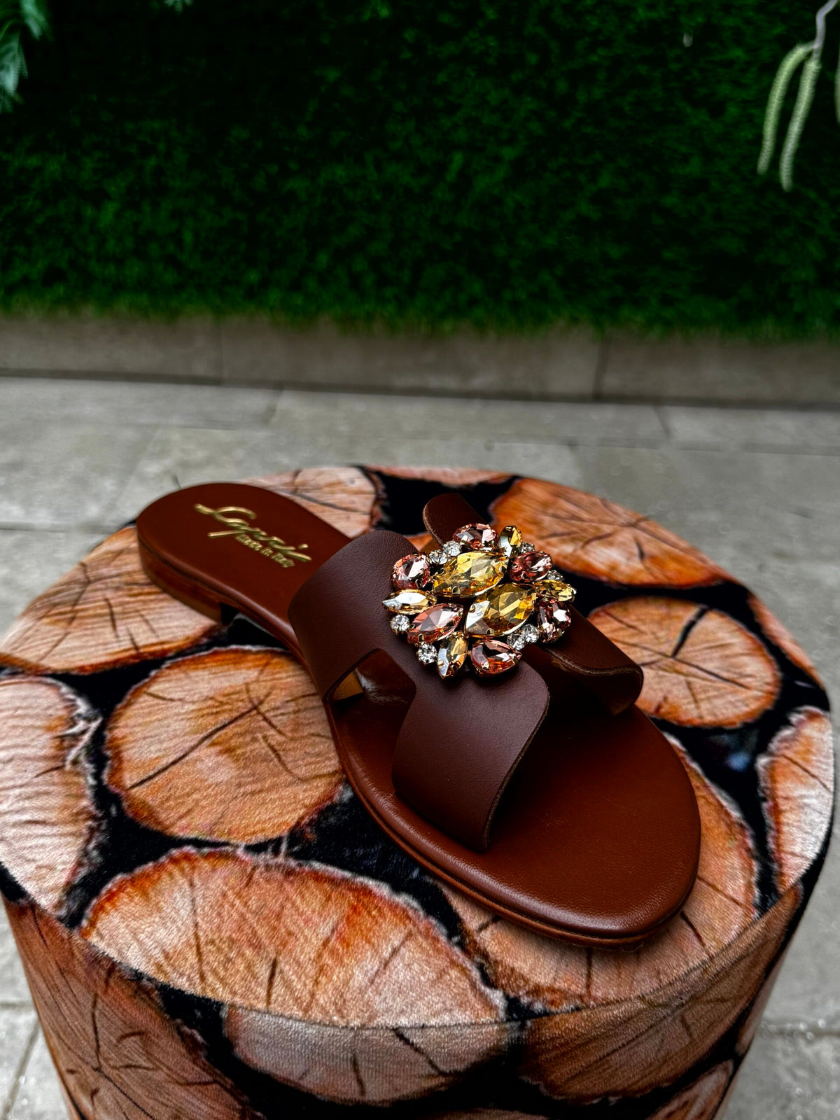 Chocolate Rose — Capri Bells SS26 Hero · Deep chocolate leather with pink champagne floral cluster